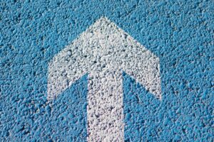 A white arrow pointing up on a blue background.